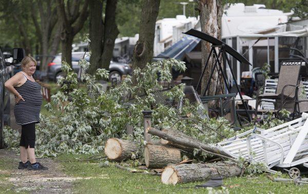 A woman surveys the damage next to a trailer home following a tornado at a campground in Saint-Roch-de-l'Achigan, near Montreal, Que., on July 12, 2019. (Graham Hughes/The Canadian Press)