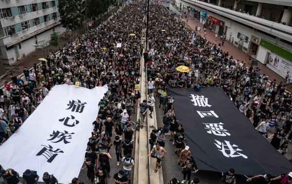Protesters hold banners as they take part in a march against a controversial extradition bill on July 14, 2019 in Sha Tin district, Hong Kong. (Anthony Kwan/Getty Images)