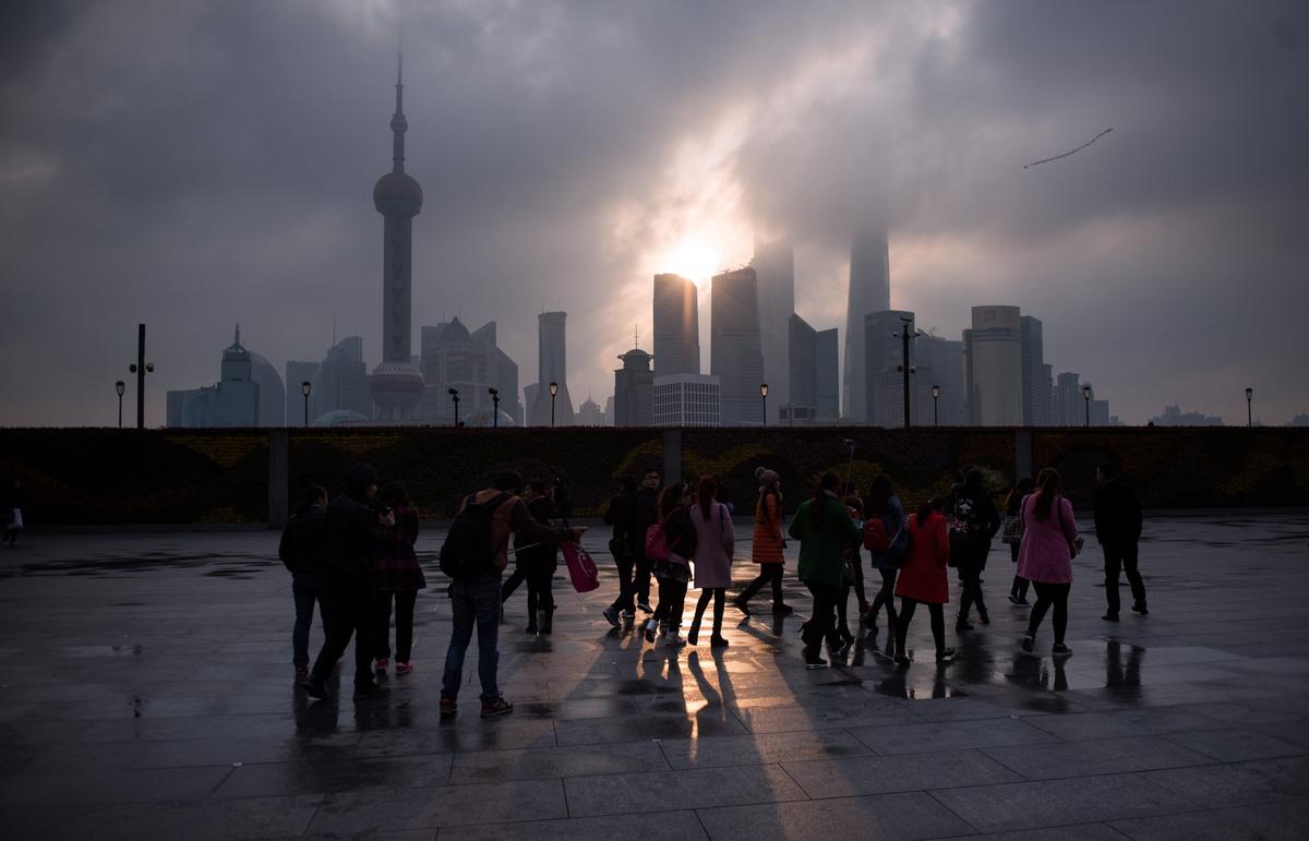 A group of tourists stand by the Bund near the Huangpu river across the Pudong New Financial district, in Shanghai, China on March 14, 2016. (Johannes Eisele/AFP/Getty Images)