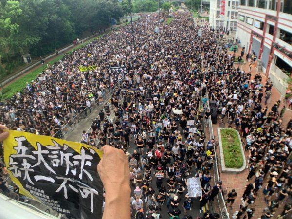 Protesters take part in a march against a controversial extradition bill on July 14, 2019 in Sha Tin district, Hong Kong. The banner in the front reads, “All five demands have to be met.” (Li Yi/The Epoch Times)