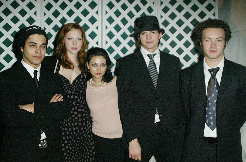 The cast of "That '70s Show" (L-R) Wilmer Valderrama, Laura Prepon, Mila Kunis, Ashton Kutcher, and Danny Masterson pose in LA, 2003 (©Getty Images | <a href="https://www.gettyimages.com/detail/news-photo/actors-wilmer-valderrama-laura-prepon-mila-kunis-ashton-news-photo/2791777">Frazer Harrison</a>)