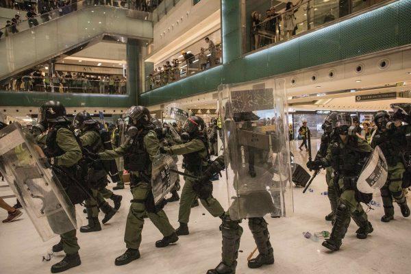 Riot police chase protesters through a shopping mall as they clash with protesters after taking part in a pro-democracy march in Hong Kong on July 14, 2019. (Chris McGrath/Getty Images)