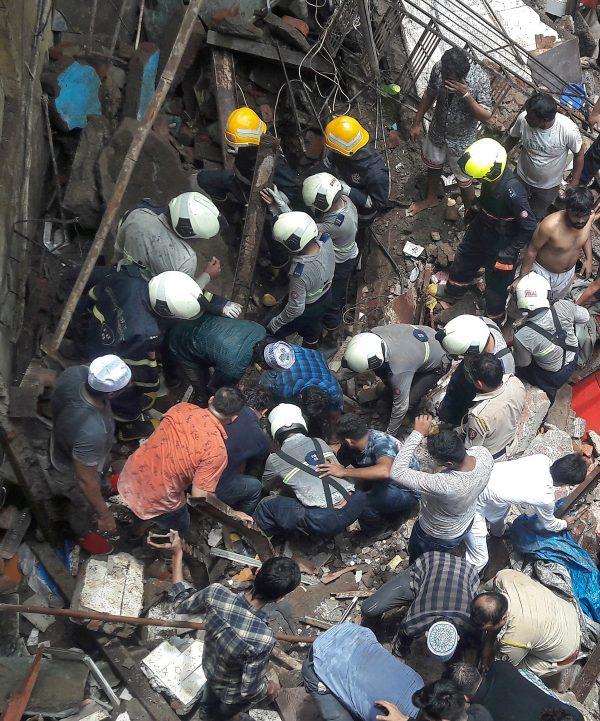 Rescue workers and residents search for survivors at the site of a collapsed building in Mumbai, India on July 16, 2019. (Stringer/Reuters)