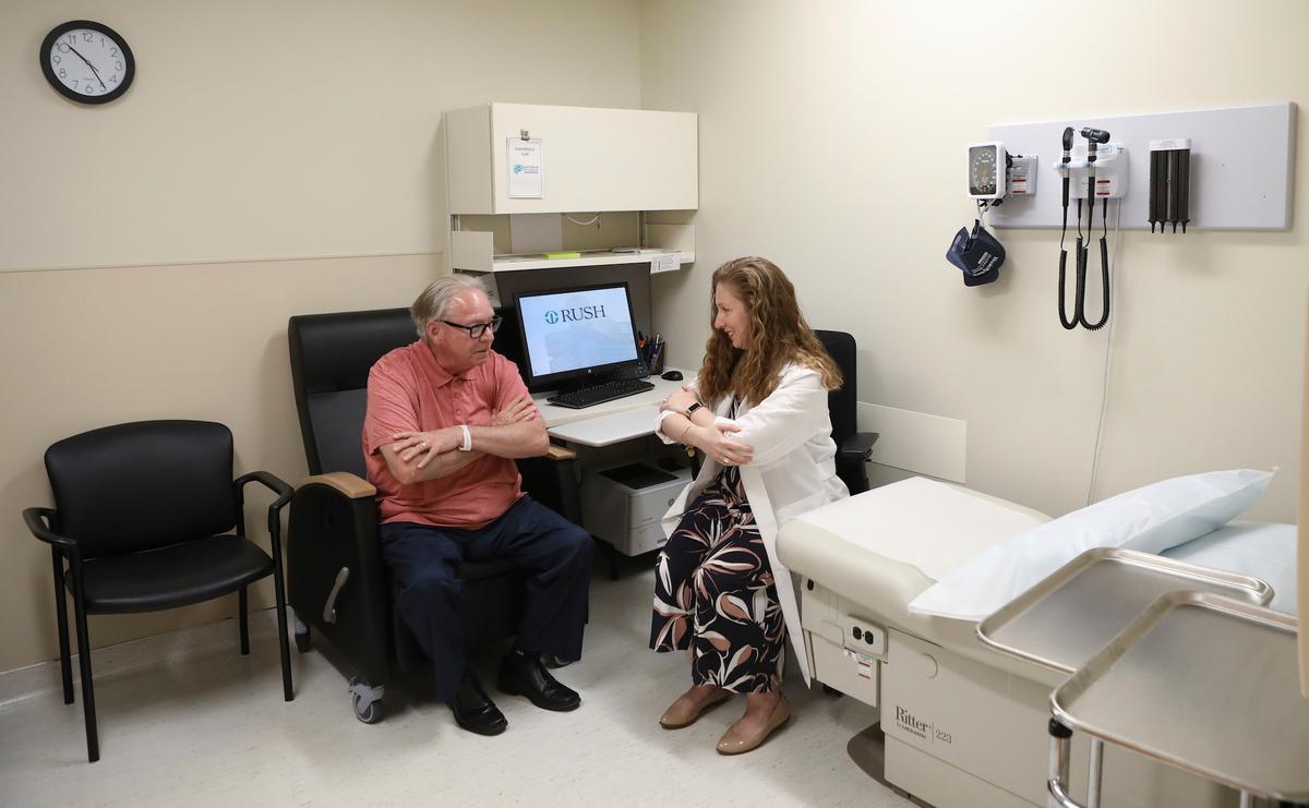 In this July 9, 2019 photo, Dr. Jori Fleisher, neurologist, examines Thomas Doyle, 66, at the Rush University Medical Center in Chicago. Doyle, 66, hopes blood tests may someday replace the invasive diagnostic testing he endured to be diagnosed 4.5 years ago with Lewy body dementia. (AP Photo/Teresa Crawford)