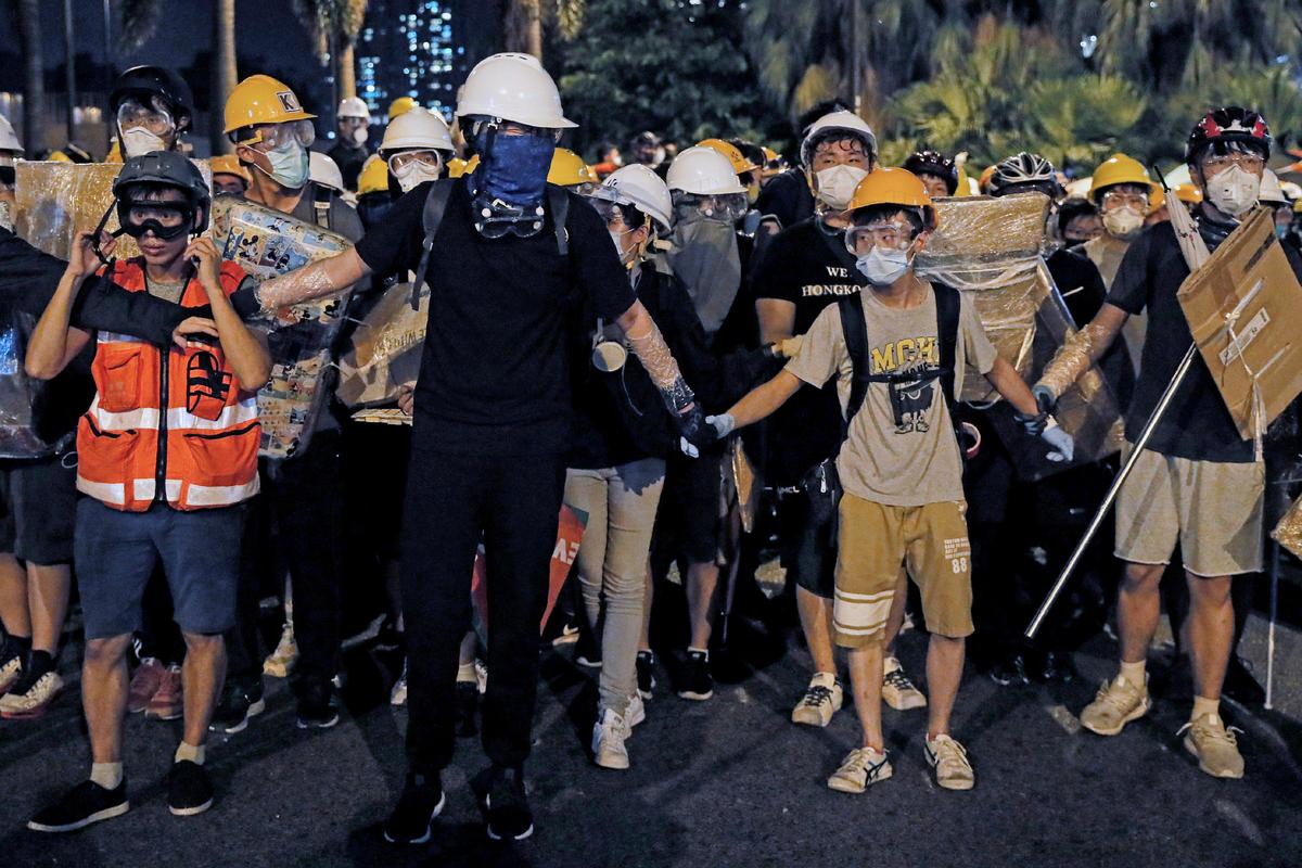Protesters wearing protection gears as they prepare to face-off with policemen on a street in Sha Tin District in Hong Kong, China on July 14, 2019. (Kin Cheung/AP)