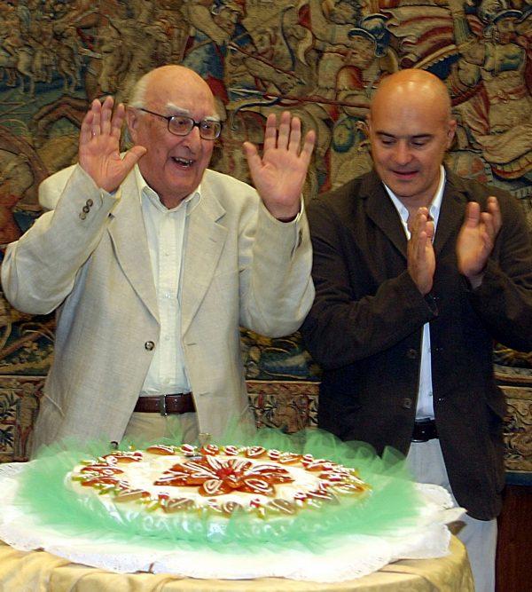Italian author Andrea Camilleri, left, flanked by actor Luca Zingaretti, celebrates his 80th birthday, at the RAI headquarters, in Rome on Sept. 14, 2005. (Sandro Pace/File Photo via AP)