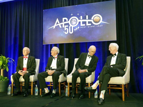 Apollo Legends attend a news conference from left, Gerry Griffin, Apollo flight director, and Charlie Duke, Apollo 16 astronaut, take their seats as Mike Collins, Apollo 11 astronaut admires Apollo 9 astronaut Rusty Schweickart's socks featuring a Saturn V rocket, during a news conference in Cocoa Beach, Fla, on July 16, 2019. (John Raoux/AP Photo)