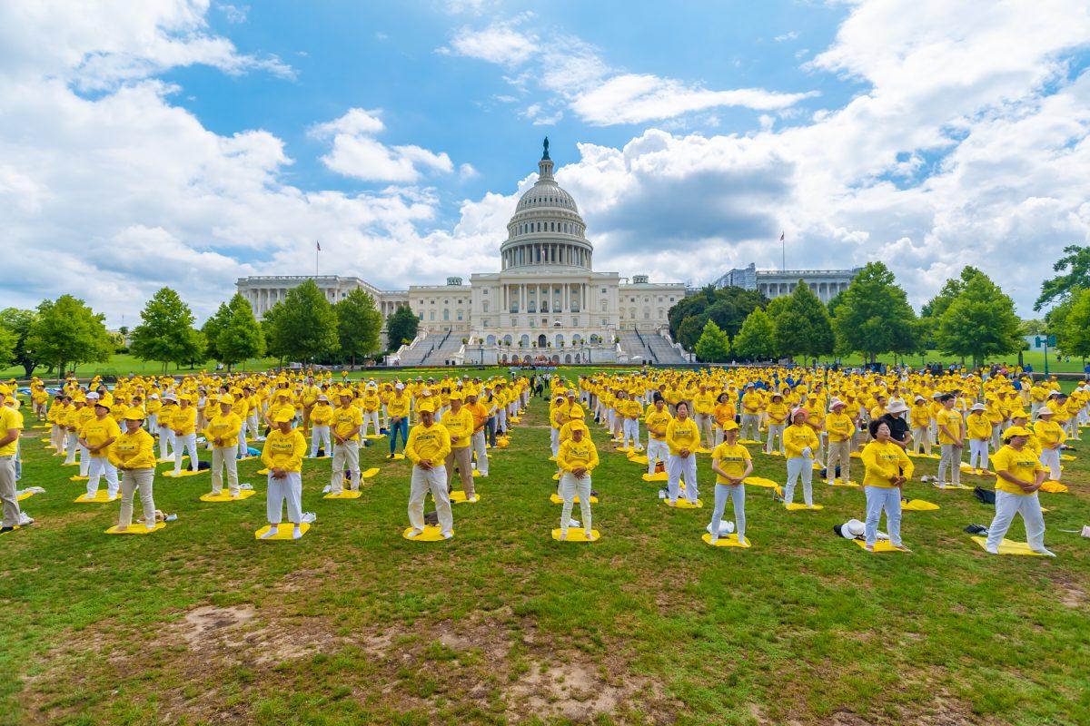 Falun Gong practitioners perform the exercises at a rally commemorating the 20th anniversary of the persecution of Falun Gong in China, on the West Lawn of Capitol Hill on July 18, 2019. (Mark Zhou/The Epoch Times)