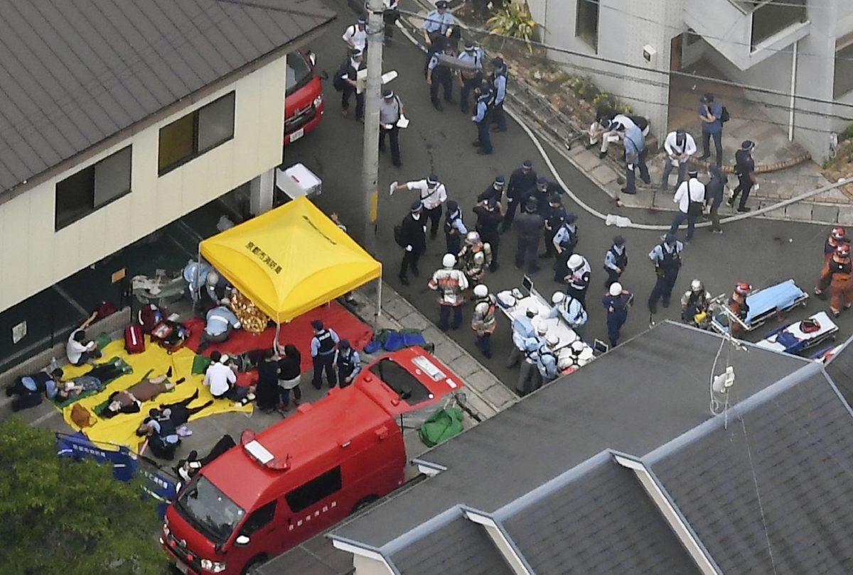People injured in a fire are treated near a Kyoto Animation building in Kyoto, western Japan, on July 18, 2019. (Kyodo News via AP)