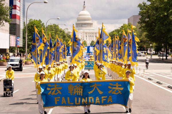Falun Gong practitioners march from the U.S. Capitol to the Washington Monument to commemorate the 20th anniversary of Chinse regime's persecution of the practice on July 18, 2019. (Larry Dye/The Epoch Times)