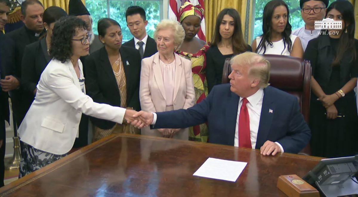 President Donald Trump shakes hands with Yuhua Zhang, a Falun Gong practitioner who survived persecution in China, at the White House on July 17, 2019. (Screenshot/The White House)