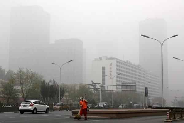 A street cleaner wears a mask against pollution in Beijing as the Chinese capital is blanketed by heavy smog on Nov. 14, 2018. (AP Photo/Andy Wong)