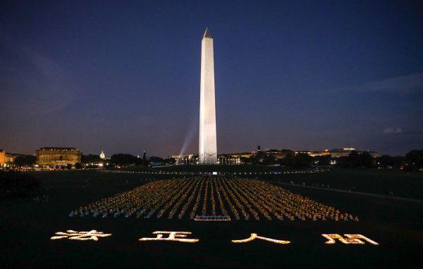 Hundreds of Falun Gong practitioners participate in a candlelight vigil to commemorate the victims of the Chinese regime's 20-year persecution of the faith in front of the Washington Monument on July 18, 2019. (Samira Bouaou/The Epoch Times)