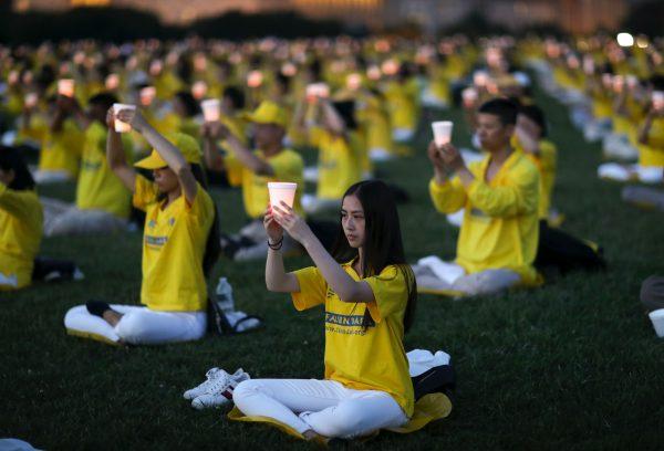 Falun Gong practitioners participate in a candlelight vigil to commemorate the victims of the Chinese regime's 20-year persecution of the faith in front of the Washington Monument on July 18, 2019. (Samira Bouaou/The Epoch Times)