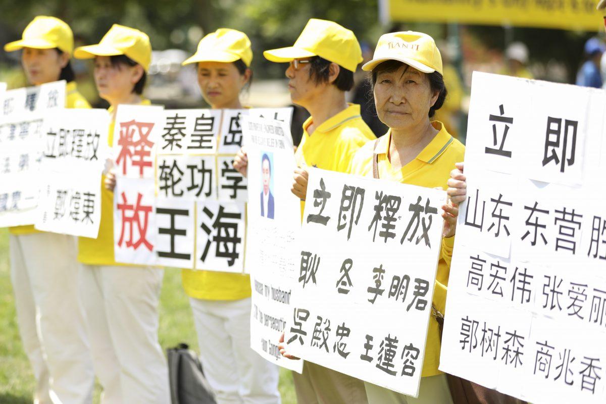 Falun Gong practitioners hold hand-made signs calling for the release of imprisoned practitioners in China in a rally commemorating the 20th anniversary of the persecution of Falun Gong in China, on the West Lawn of Capitol Hill on July 18, 2019. (Samira Bouaou/The Epoch Times)