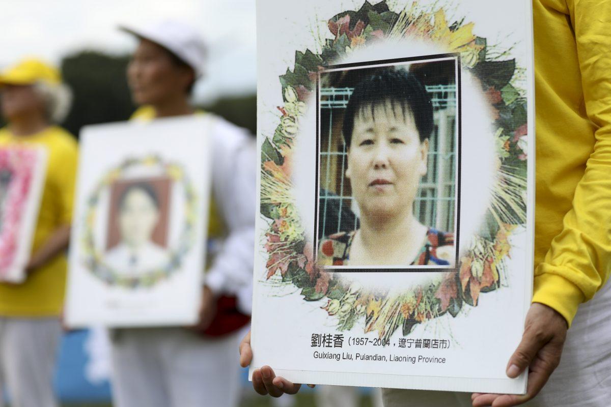 Falun Gong practitioners hold photos of fellow practitioners killed by the Chinese regime for their belief in Falun Gong, at a rally commemorating the 20th anniversary of the persecution of Falun Gong in China, on the West Lawn of Capitol Hill on July 18, 2019. (Samira Bouaou/The Epoch Times)