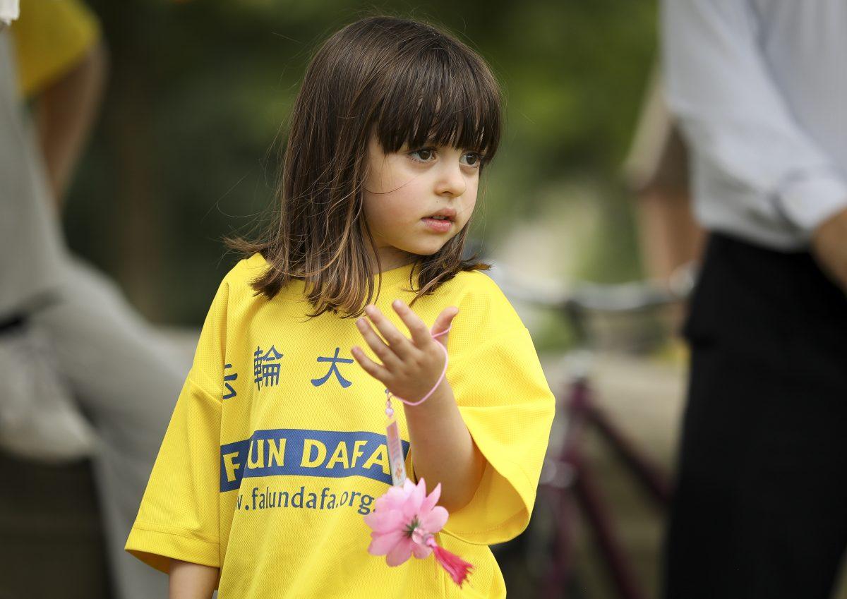  A young girl takes part in a rally commemorating the 20th anniversary of the persecution of Falun Gong in China, on the West Lawn of Capitol Hill on July 18, 2019. (Samira Bouaou/The Epoch Times)