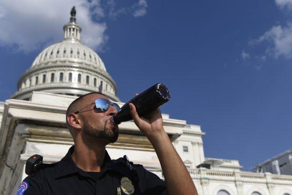 A Capitol Hill police officer takes a drink as he stands his post on the West side of Capitol Hill in Washington, on July 20, 2019. (Susan Walsh/AP Photo)