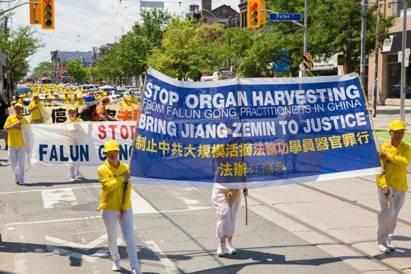Falun Gong practitioners raise banners in protest of the persecution in China against their practice. (Wen Ai/The Epoch Times)