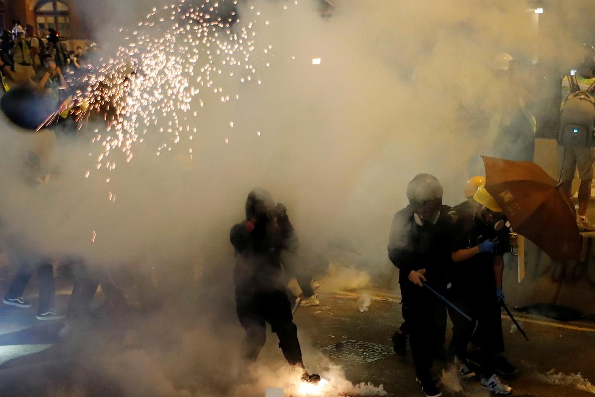 Anti-extradition bill demonstrators react as riot police fire tear gas after a march to call for democratic reforms in Hong Kong, China on July 21, 2019. (Tyrone Siu/Reuters)