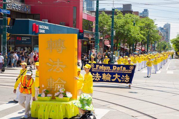 Part of the Falun Gong parade's procession. This bright gold float, supported by a group of practitioners, features the spiritual guidebook "Zhuan Falun" written by founder Mr. Li Hongzhi. (Wen Ai/The Epoch Times)