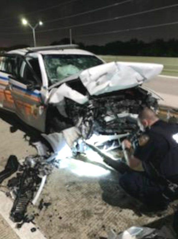 An officer examines the patrol car hit in a wrong-way crash in Harris County on July 21. (Harris County Sheriff's Office)
