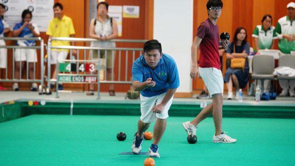Michael Cheung (delivering) partnered with Chan Ka Yue (not in photo) to defeat his Hong Kong Youth Development team teammate Lyndon Sham (at the back) and Kenneth Yiu at the final of the 18-25 years old group at the U25 Age Group Lawn Bowls Competition. The game needed an extra end to decide the winner. (Mike Worth)