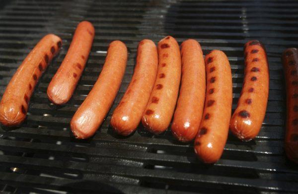 Hot dogs on a grill. (Mark Lennihan/AP Photo)