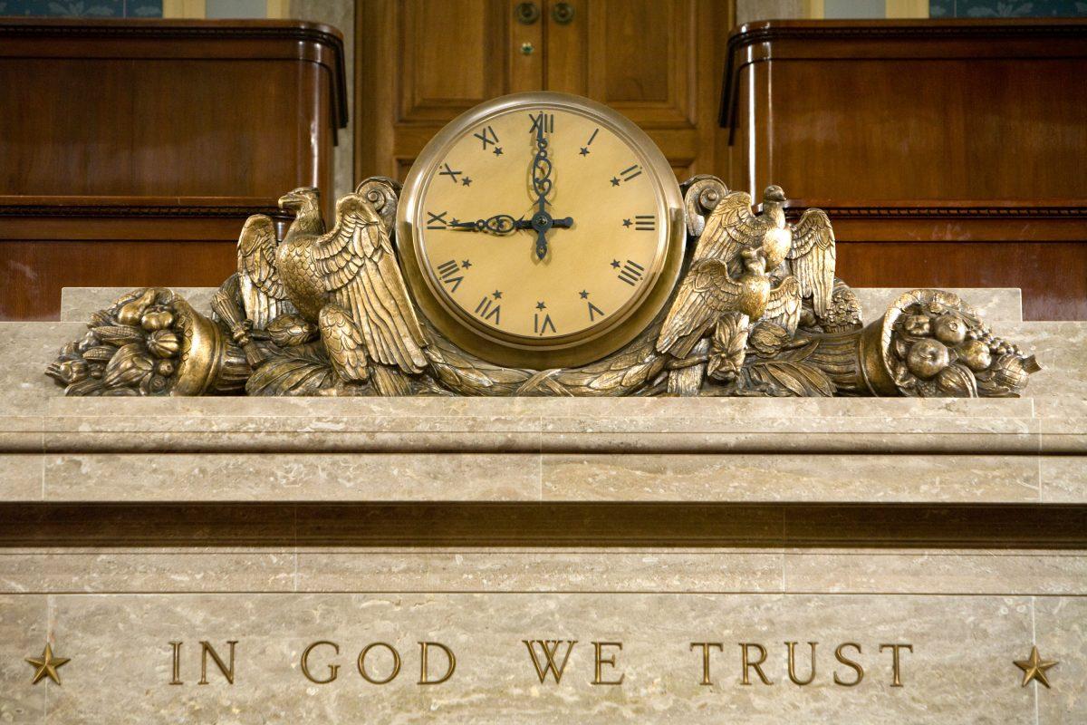 A clock and the motto "In God We Trust" over the Speaker's rostrum in the U.S. House of Representatives chamber are seen in Washington in a file photo. (Brendan Hoffman/Getty Images)