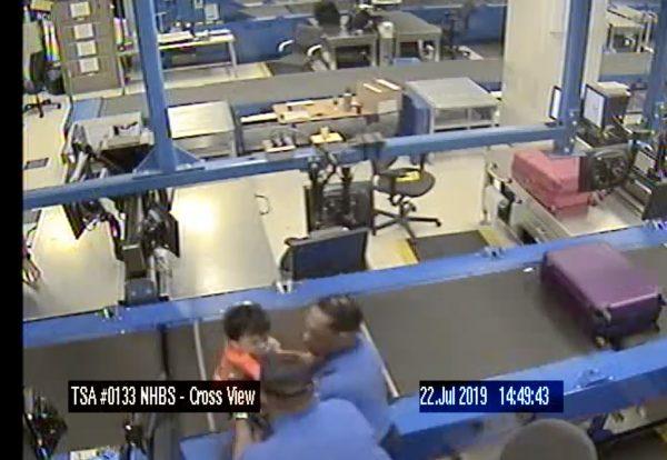 Staff rescues the toddler from the conveyor on July 22 at Atlanta airport. (Atlanta International Airport)