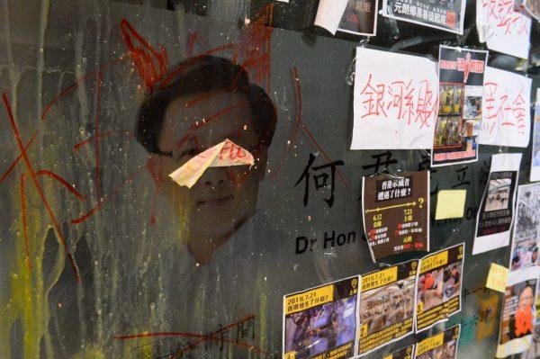 A portrait of pro-Beijing lawmaker Junius Ho is seen egged and covered with placards and memos in Ho's office in Hong Kong's Tsuen Wan district on July 22, 2019. (Song Bilong/The Epoch Times)