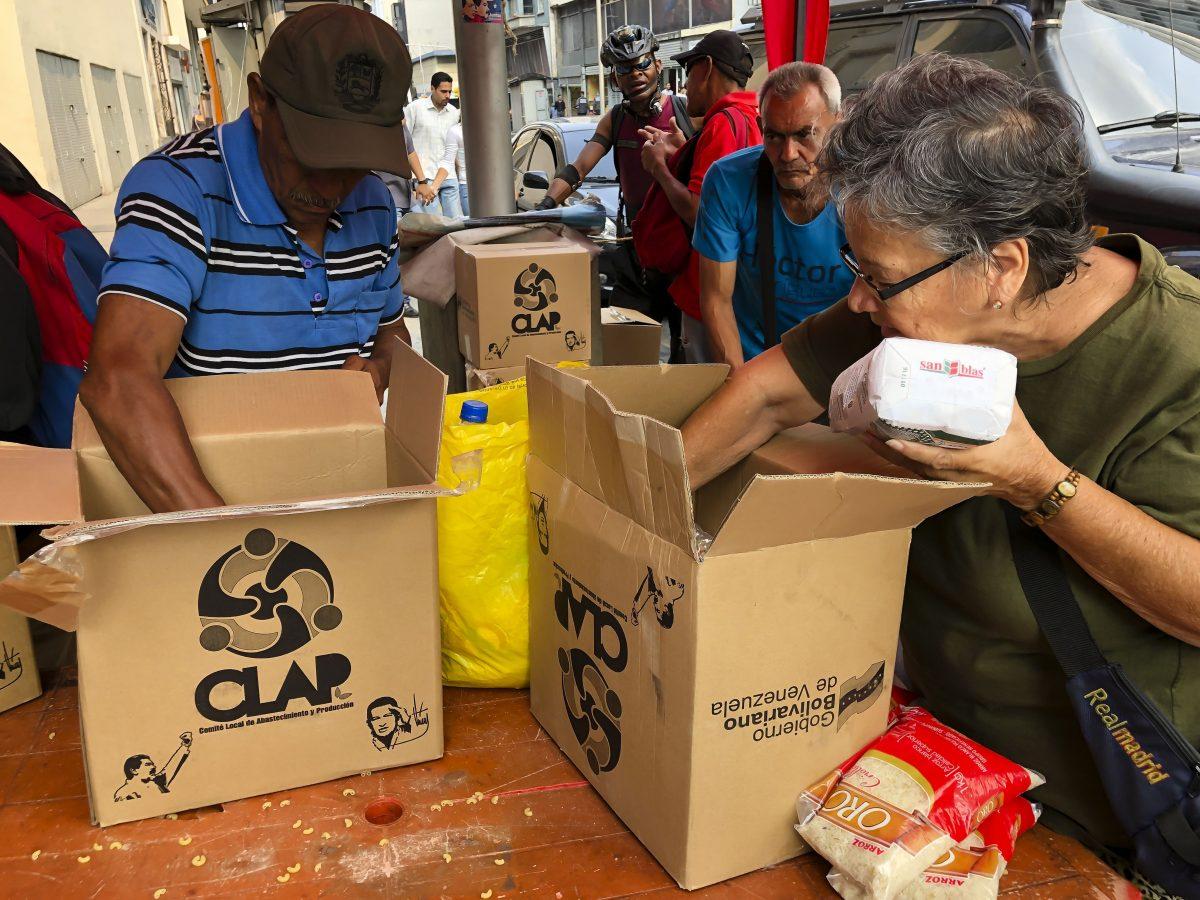 Neighbors of barrio Union of Petare open boxes of food program CLAP in Caracas, Venezuela, on April 4, 2019. (Eva Marie Uzcategui/Getty Images)