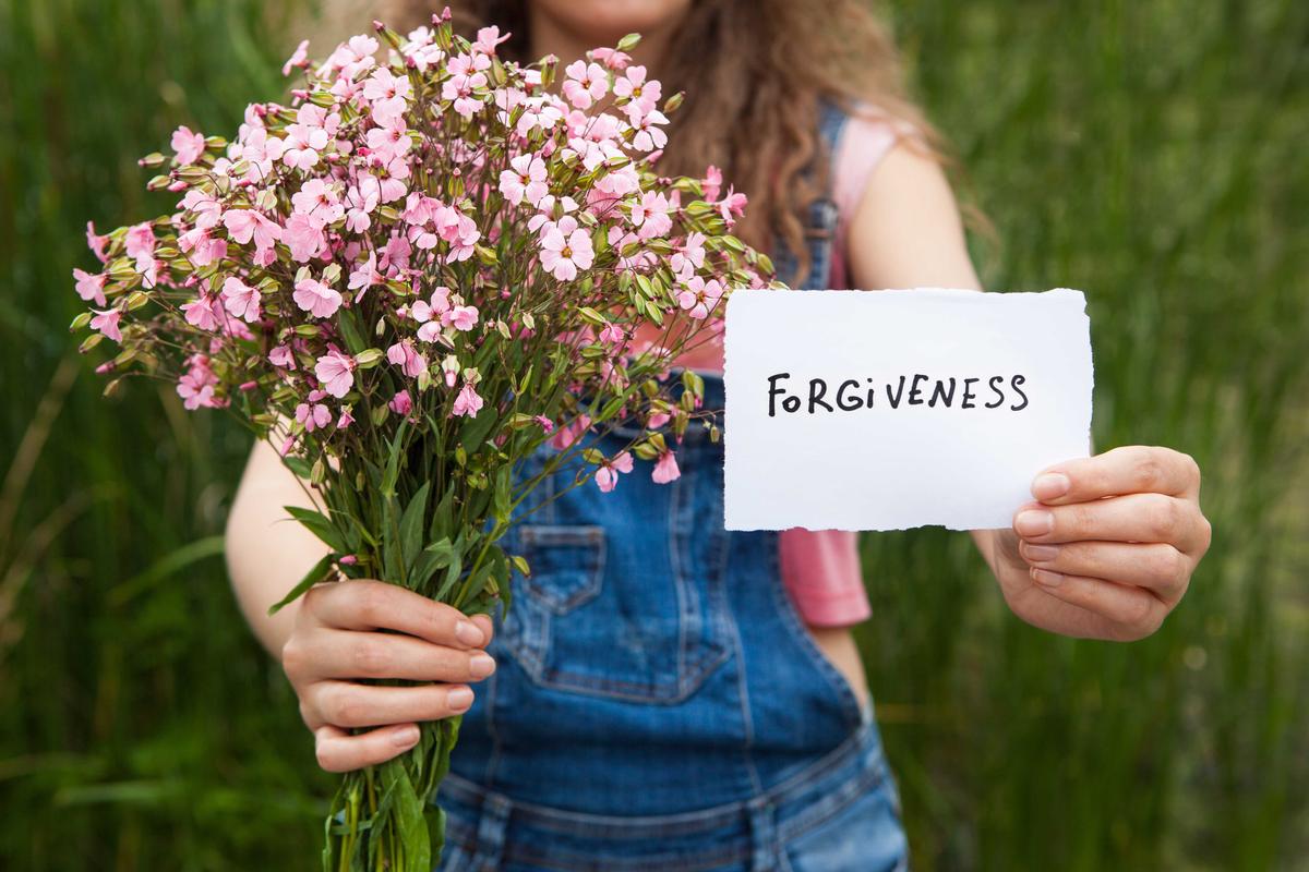 Illustration - Shutterstock | <a href="https://www.shutterstock.com/image-photo/forgiveness-woman-word-bouquet-pink-flowers-684654058?studio=1">justesfir</a>