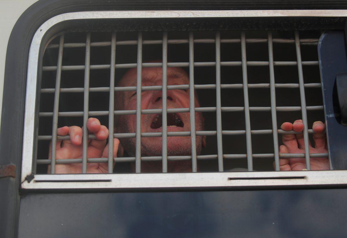 A man reacts inside a police bus after he was detained during a rally calling for opposition candidates to be registered for elections to Moscow City Duma, the capital's regional parliament, in Moscow, Russia, on July 27, 2019. (Maxim Shemetov/Reuters)