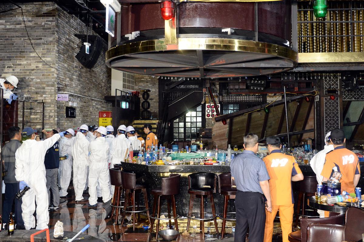 South Korean firefighters and officials examine the collapsed structure of a nightclub where several athletes competing at the World Aquatics Championships were dancing, in Gwangju, South Korea, July 27, 2019. (Yonhap via Reuters)