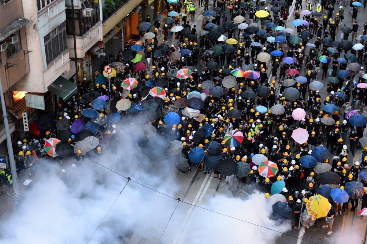 Riot police fire tear gas at Des Voeux Road Central in Hong Kong, on July 28, 2019. (Song Bilong/The Epoch Times)