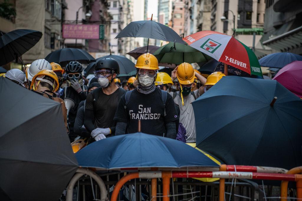 Masked protesters stand behind a makeshift barricade during a demonstration in the area of Sai Wan in Hong Kong, on July 28, 2019. (Laurel Chor/Getty Images)