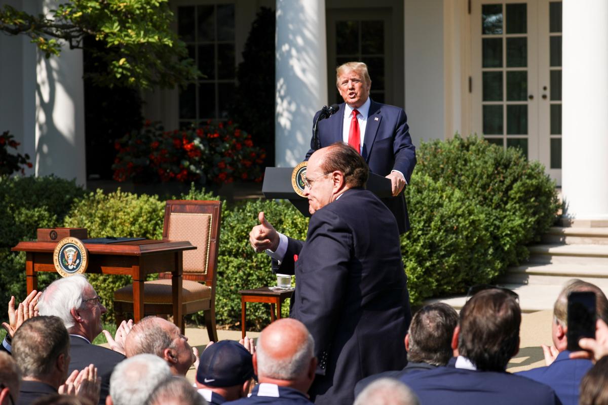 President Donald Trump asks former New York City Mayor Rudy Giuliani to stand at the signing of the 9/11 Victim Compensation Fund bill in the White House Rose Garden on July 29, 2019. (Charlotte Cuthbertson/The Epoch Times)