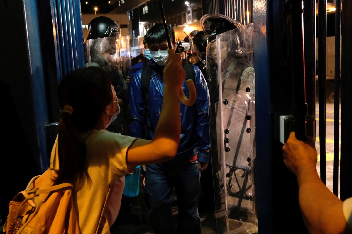 A detained anti-extradition bill protester leaves a police station on bail as his friends wait for him in Hong Kong, China on July 30, 2019. (Tyrone Siu/Reuters)