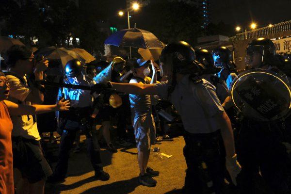 Police officers confront protesters who surrounded a police station where detained protesters are being held during clashes in Hong Kong, on July 30, 2019. (Tyrone Siu/Reuters)