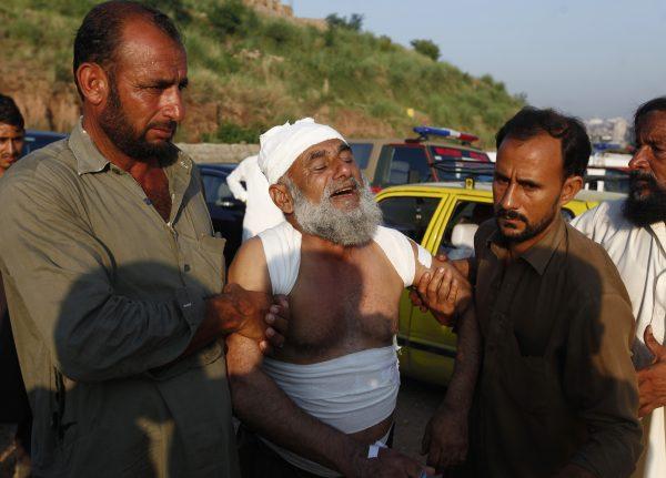 People help an injured victim who morns for the lost of his family member at the site of plane crash in Rawalpindi, Pakistan on July 30, 2019. (Anjum Naveed/AP Photo)