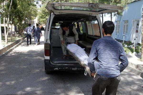 Afghans carry the dead body of a victim in a hospital after a roadside bomb on the main highway between the western city of Herat and the southern city of Kandahar, in Herat, Afghanistan on July 31, 2019. (Hamed Sarfarazi/AP Photo)