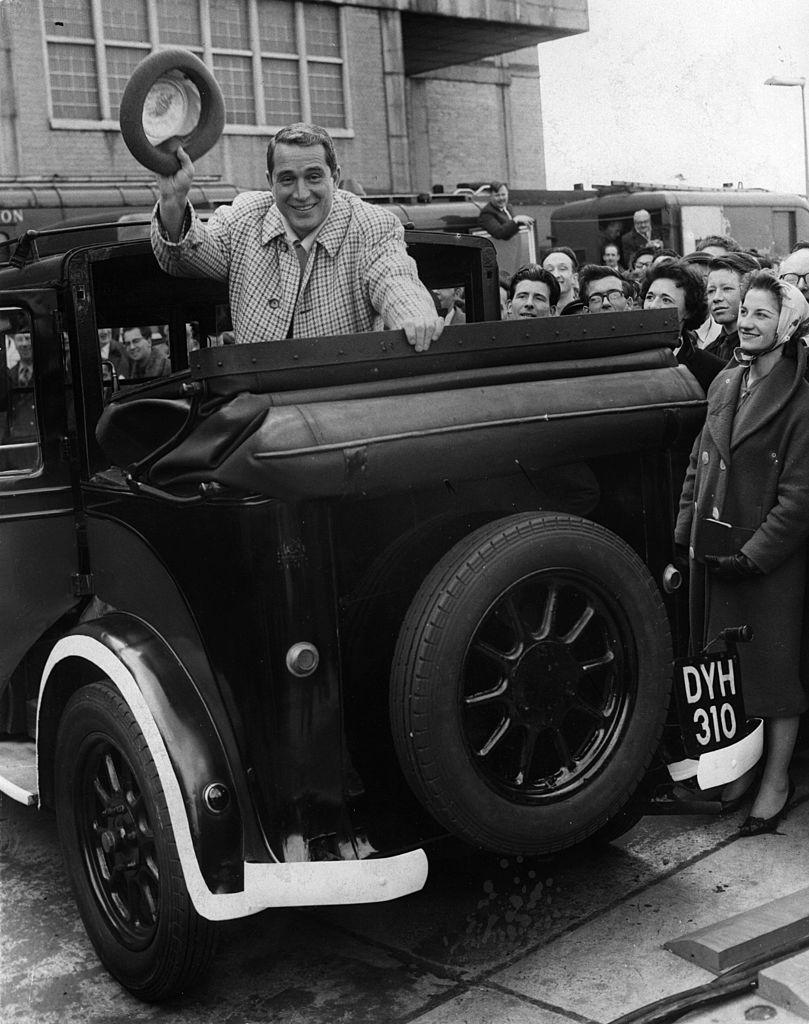 Perry Como greets fans and rides off in a black cab after landing at London airport on April 16, 1960 (©Getty Images | <a href="https://www.gettyimages.com.au/detail/news-photo/american-singer-perry-como-rides-in-an-old-taxi-after-his-news-photo/3315663">Keystone</a>)