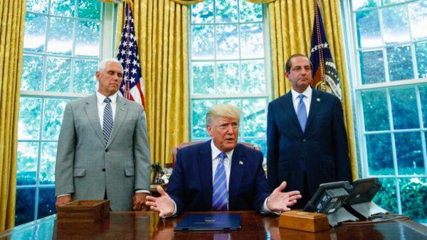 President Donald Trump, joined by Vice President Mike Pence (L) and Secretary of Health and Human Services Alex Azar (R), speaks during a signing ceremony in the Oval Office of the White House in Washington on July 1, 2019. (AP Photo/Carolyn Kaster)