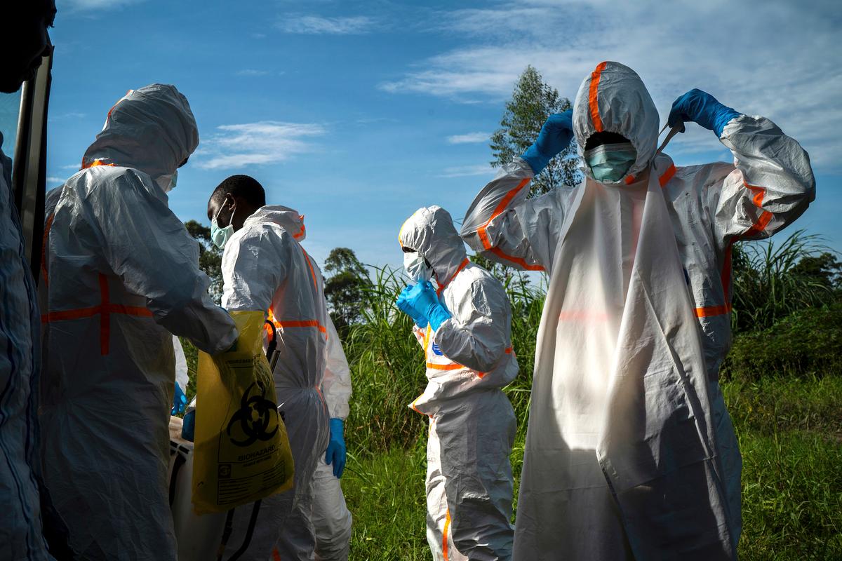 Burial workers put on their protective gear before carrying the remains of Mussa Kathembo, an Islamic scholar who had prayed over those who were sick, and his wife Asiya to their final resting place in Beni, Congo DRC, on July 14, 2019. Both died of Ebola. More than 1,600 people in eastern Congo have died as the virus has spread in areas too dangerous for health teams to access. (AP Photo/Jerome Delay)