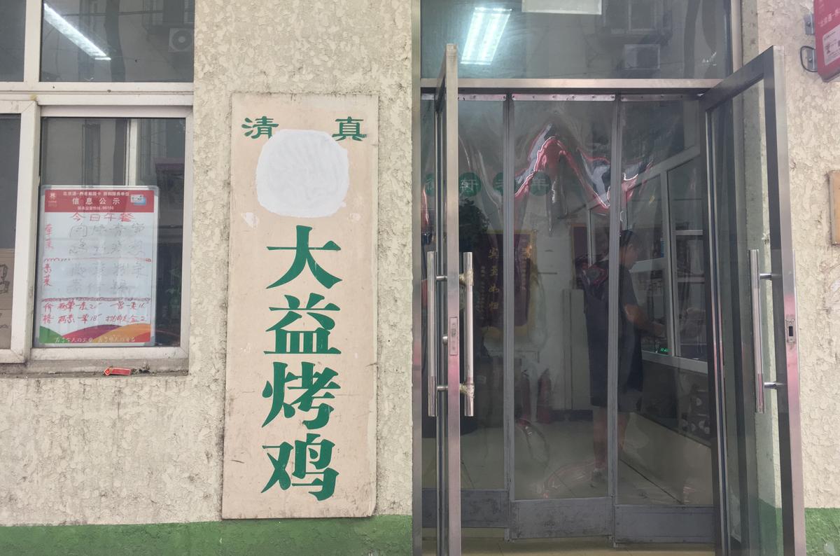 The Arabic script on a halal sign outside a store is seen covered, at Niujie area in Beijing on July 19, 2019. (Reuters)