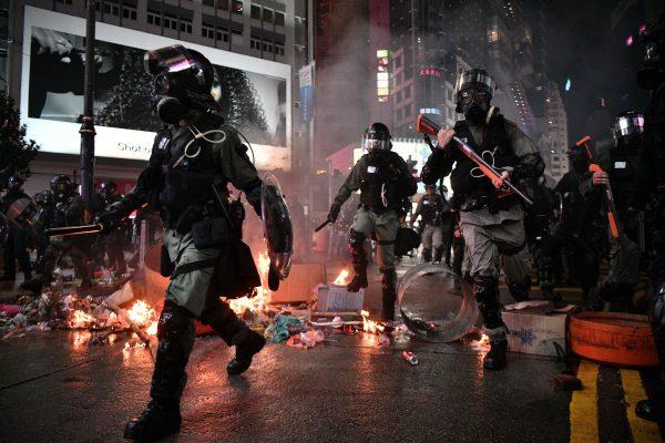 Police run past debris set alight by protesters in the Causeway Bay area of Hong Kong on Aug. 31, 2019. (Anthony Wallace/AFP/Getty Images)