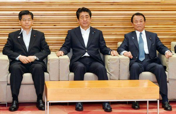 (L-R) Japan's Land, Infrastructure and Transport Minister Keiichi Ishii, Prime Minister Shinzo Abe and Finance Minister Taro Aso attend a Cabinet meeting in Tokyo on Aug. 2, 2019. (Yoshitaka Sugawara/Kyodo News via AP)