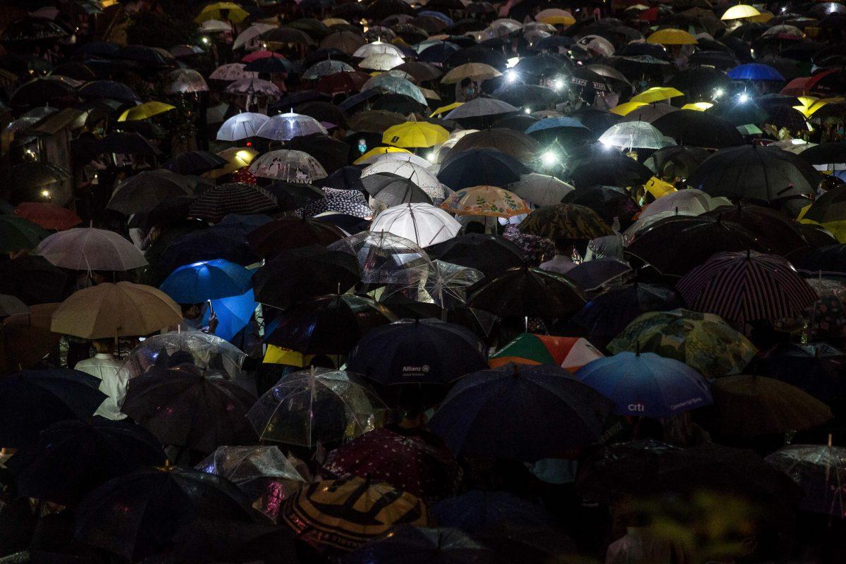 People from the finance community hold up umbrellas and shine lights during a protest against a controversial extradition bill in Hong Kong on August 1, 2019. (Isaac Lawrence/AFP/Getty Images)