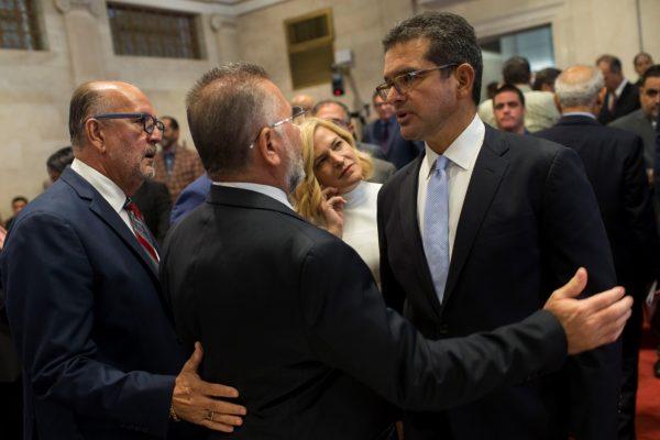 Proposed Secretary of State Pedro Pierluisi (R) is greeted by lawmakers Luis Ortiz and Jose Aponte during a break in his confirmation hearing at the House of Representatives, in San Juan, Puerto Rico, on Aug. 2, 2019. (Dennis M. Rivera Pichardo/AP Photo)